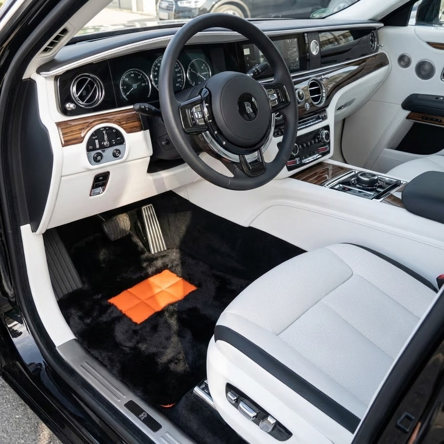 Svarte saueskinnsmatter for Rolls-Royce Spectre (2023-2024) med oransje lærdetaljer