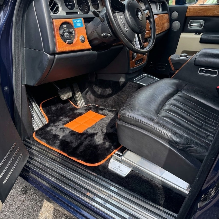 Svarte saueskinn Bilmatter for Rolls-Royce Phantom VIII (2017-2024) med oransje lærdetaljer
